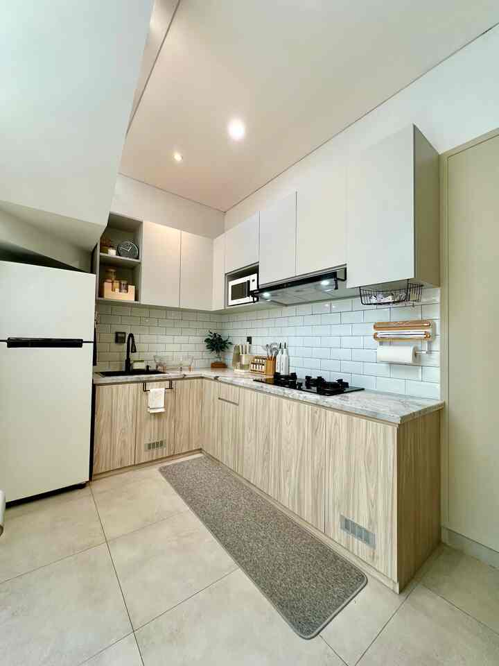 White and beige toned kitchen with L-shaped cabinetry, featuring a clean and modern design