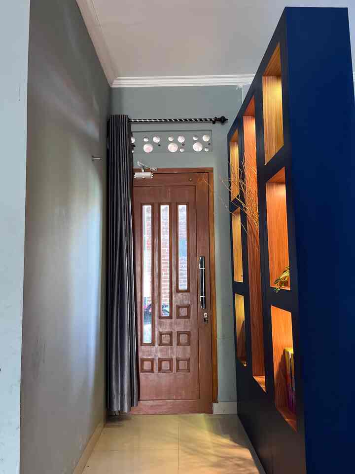 Entrance with blue and brown tones featuring illuminated shelves and wooden door in a cozy setting