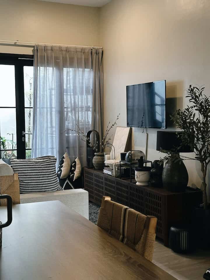 Aku udah punya beberapa ide dekorasi kece buat tiap sudut rumah nih:

1. Lampu meja hitam di ruang keluarga: 
pas banget sama dekorasi lain. Aku tuh emang cinta warna hitam, apalagi kalau dipadukan sama meja TV kayu jati yang natural. Kombinasi simpel tapi classy!

2. Ambalan hitam di area kerja: lengkap sama dekorasi serba hitam. Supaya nggak terlalu monoton, cat dindingnya aku pilih warna sage green biar vibes-nya lebih fresh dan hidup.

3. Bantal kursi hitam putih: matching banget sama sofa BW di ruang keluarga. Polanya ngikutin tema monochrome tapi tetap cozy.

4. Frame foto dan bantal kursi di ruang tamu: bikin suasana ruang tamu langsung naik kelas jadi lebih elegan.

5. Lampu meja plus lukisan abstrak warna nude kekuningan buat ruang tamu: Kombinasi ini bikin ruang tamu terasa lebih hangat dan sophisticated.

6. Kaca bulat besar di meja makan: trik simpel supaya ruangnya terasa lebih luas. Efek visualnya tuh bener-bener ngaruh!

7. Pot gantung di fasad rumah plus tirai Onna warna hitam di ruang tamu: Estetik banget, dan kalau malam jadi nggak terlalu kelihatan dari luar—intim banget.

Gimana, nggak cuma estetik kan? Semuanya tetap fungsional juga! 😎✨ Mana yang favoritmu?

#HomeDecorGoals #MonochromeStyle #ElegantSpaces #CozyVibes #RoomMakeover #HomeyFeels #InteriorInspo #FunctionalBeauty #WarmAndMinimalist #bantalkursi #lukisaninterior #catinterior #DekorasiEstetik #SmallDecorItems #DecorativeItems