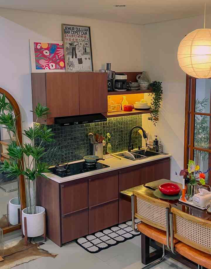 Brown and green toned kitchen and dining room with wooden furniture and plants, creating a cozy space