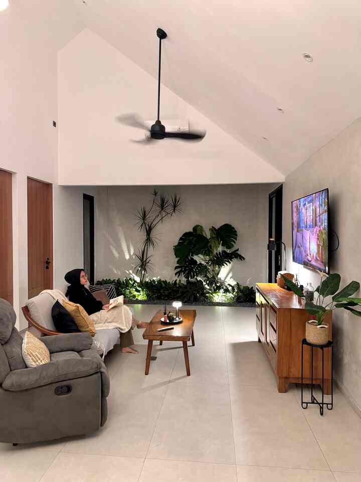 Natural-toned modern living room featuring wooden furniture and abundant plants with a cozy atmosphere