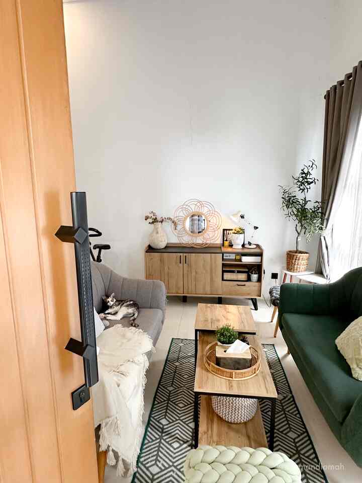 Begitu masuk melalui pintu utama rumah ini, langsung ada living room berisi 2 seater berhadapan, juga credenza/kabinet mepet tembok-tegak lurus dengan pintu utama. Credenza ini memiliki karakter dan design yang senada dengan meja ruang tamu. 

Selain uniknya stool dan sofa 2 seater tersebut, dekorasi credenza juga yang menjadi salah satu spot menarik di ruang tamu ini. Di atasnya ada beberapa item dekorasi seperti cermin rotan, tanaman artifisial dengan pot, juga table lamp. Penempatan olive tree di pojok ruangan dekat jendela juga membuat ruangan tampak lebih hidup🍃

#Credenza #SofaRuangTamu #Stool #DekorasiEstetik #SmallDecorItems #DecorativeItems #livingroomdecor #livingroominspo #nyamandiomah
