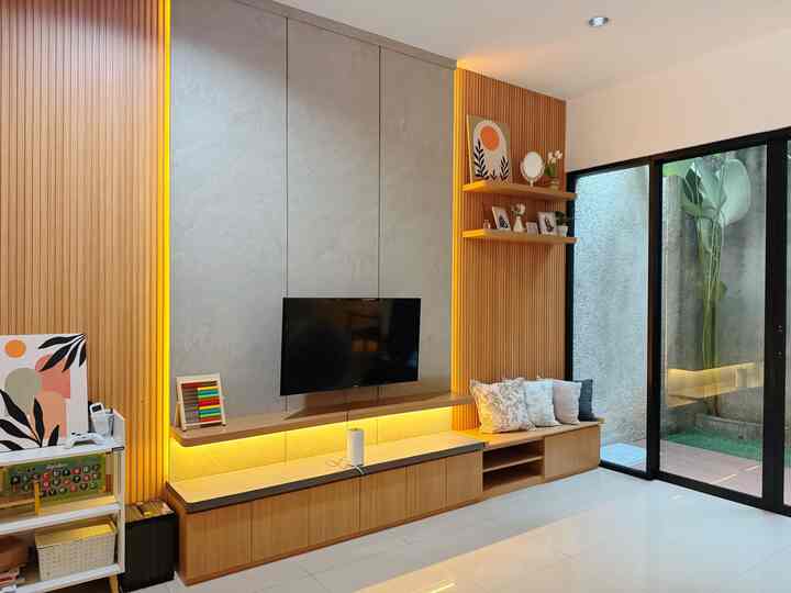 Natural wood tone living room featuring custom bench and family photo frames with warm ambiance