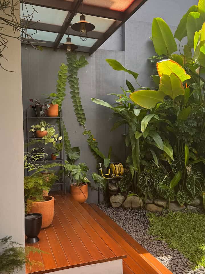 Natural color and wood tone balcony featuring various plants and pendant lights with cozy outdoor atmosphere