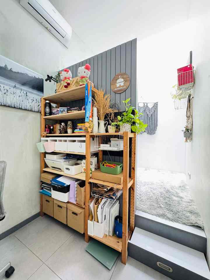 White and brown toned small home office featuring cluttered shelves, organized storage boxes, and a cozy carpeted relaxation corner