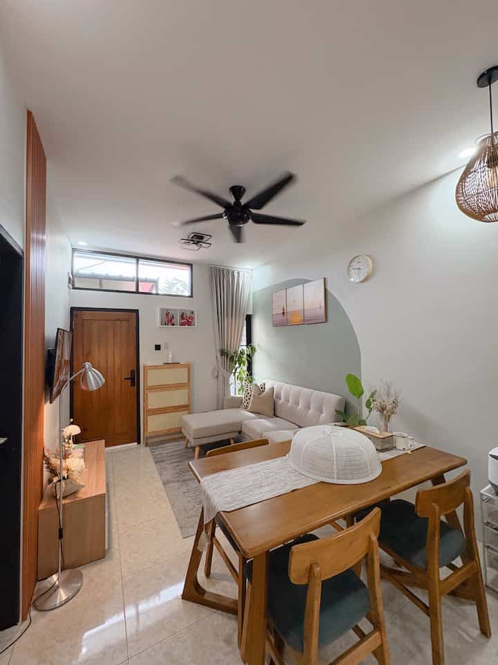 A natural-toned living and dining room featuring wooden furniture and sofa creating a cozy atmosphere