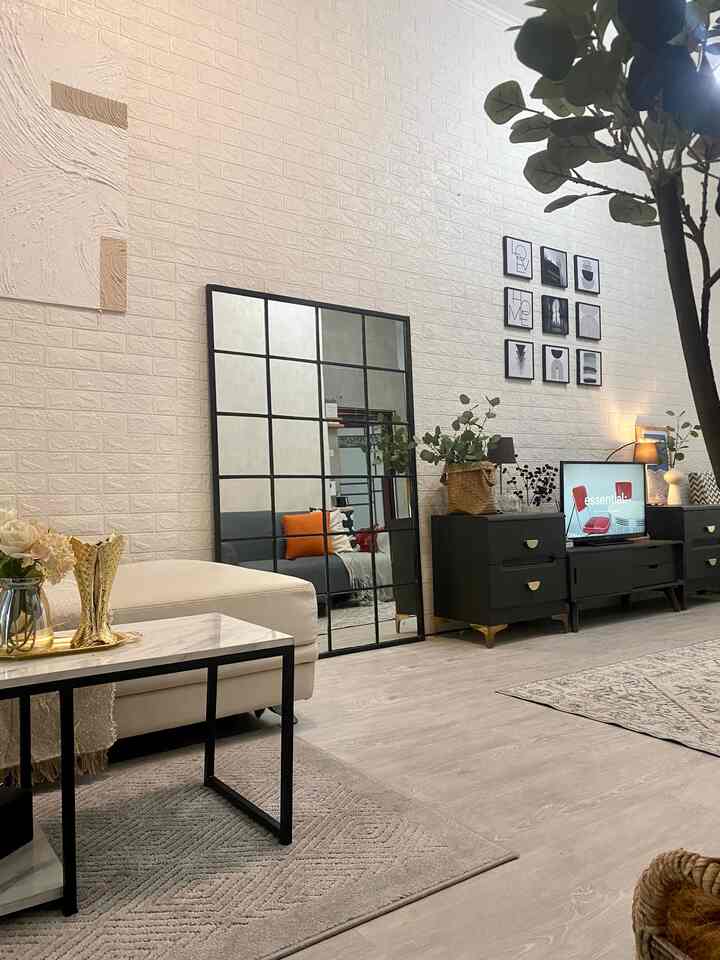 Bright beige and black-toned living room featuring large grid mirror and assorted furniture creating a cozy atmosphere