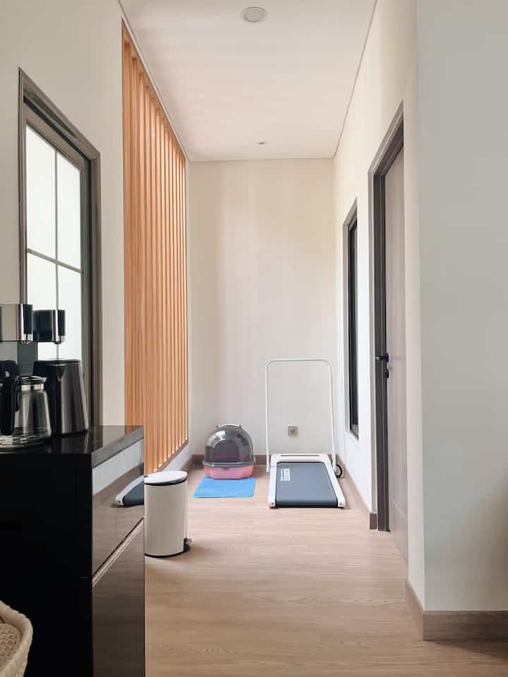 The corner on the top floor with a space that is not too big but very useful. We can do light exercise every morning while sunbathing because this treadmill area gets abundant sunlight in the morning. The glass canopy can be opened and closed so that air circulation is good. Next to the treadmill we put a litter box for pets with a door so that there is no disturbing odor.

#HomeGym
#LimitedSpace
#Treadmill
#GridTiang
#GlassCanopy
#Skylight