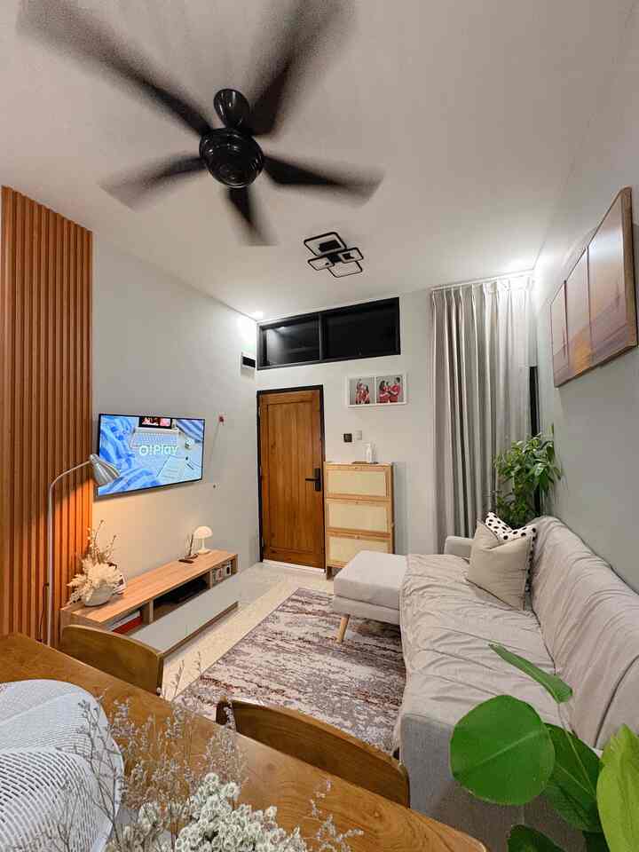 Modern living room with wood tones and beige hues featuring sofa and shoe cabinet