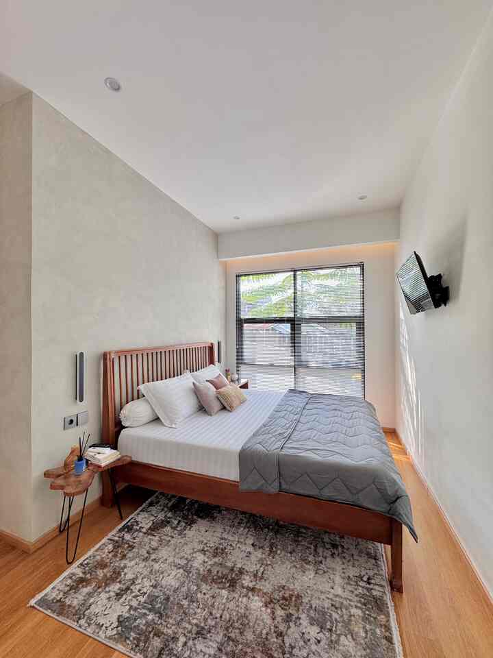 White and wood-toned bedroom featuring minimalist furniture and aluminum blinds creating a cozy atmosphere