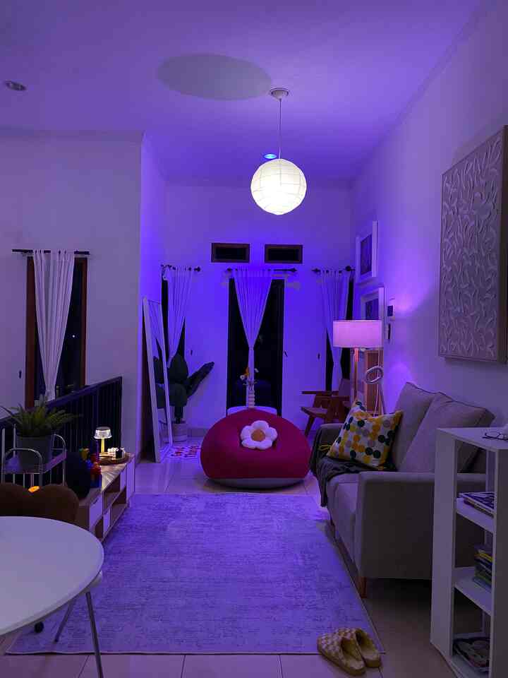 White and pink toned open-plan living and dining area featuring sofa and bean bag, creating a cozy and relaxed atmosphere