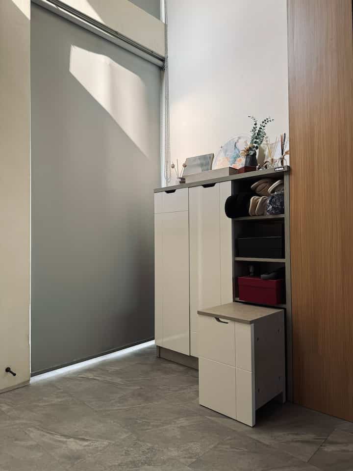 White and beige narrow entrance featuring storage cabinet and shoe cabinet for practical use
