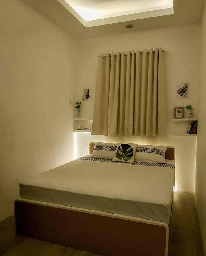 Natural-colored bedroom featuring a central bed, blackout curtains, and soft LED strip lighting creating a cozy ambiance