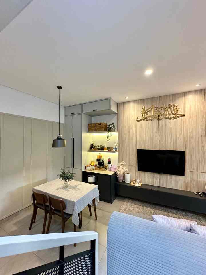 Modern dining room and living room in white and beige tones featuring dining table, pendant light, and TV stand in a cozy space
