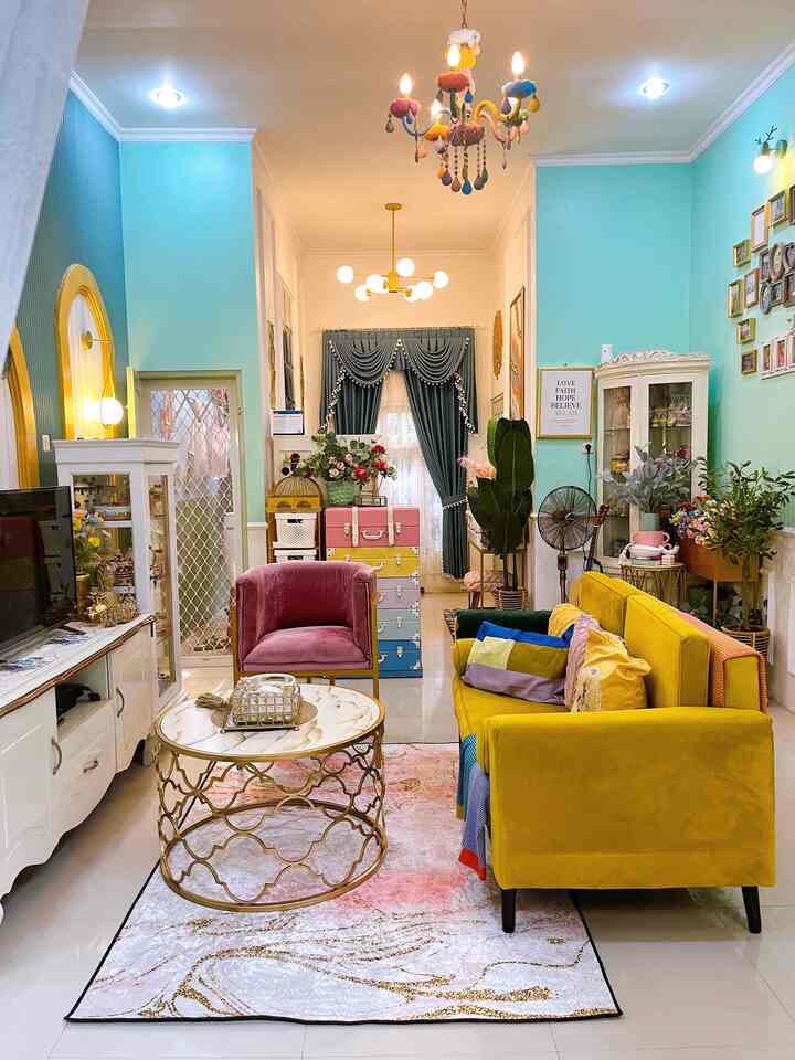 Living room with yellow sofa and pink armchair, featuring colorful tones and wall art in a spacious open space setting