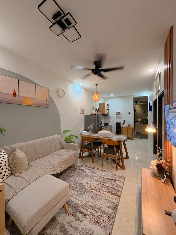 Beige and wood tone living room featuring sofa and dining table in a cozy, modern space