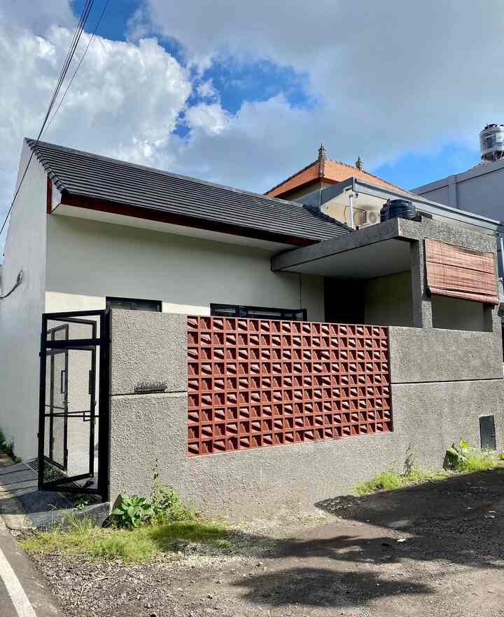 Tampil dengan karakter minimalis industrial yang kuat, PX HOME mengusung kombinasi dinding ekspos bertekstur kasar dan elemen roster merah bata yang menciptakan permainan bayangan alami. Atap pelana simpel dilapisi genteng hitam memberi kesan modern namun tetap hangat. Pintu gerbang besi hitam berpadu sempurna dengan pagar beton, menegaskan identitas tegas dan fungsional. Sentuhan alam tetap hadir lewat vegetasi kecil di sekitarnya, menyempurnakan estetika rumah yang kokoh, sederhana, namun tetap berjiwa. #InspirasiFasad #StyleFasad #FasadRumah #PagarRumah 
#PagarRumahMinimalis #WarnaCatPagar #WarnaCatRoster #NomorRumahMinimalis #TanamanHiasAesthetic #GraniteCarport #Carport #RumahIndustrial #RumahIndustrialMinimalis
