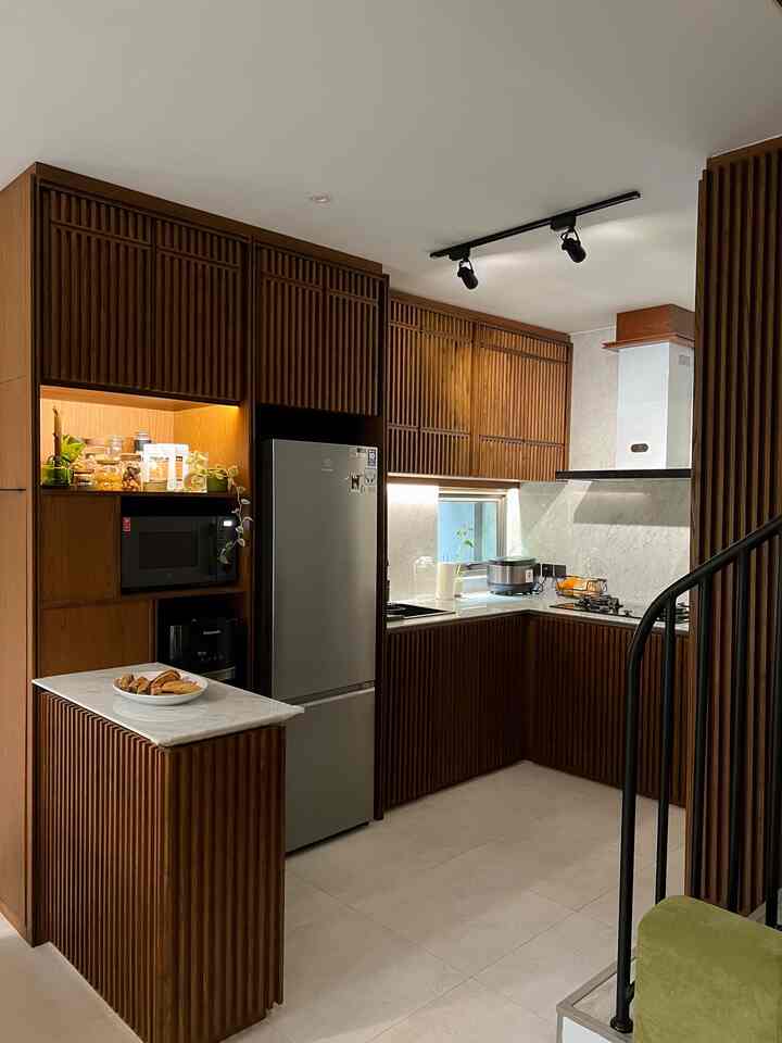 Kitchen yang jadi pusat aktivitas di rumah ini kami desain dengan mempertimbangkan dua hal utama: longlasting dan timeless.

Material yang digunakan didominasi oleh kayu solid, dipadukan dengan marmer di bagian backsplash dan top table — kombinasi yang sederhana tapi terasa hangat sekaligus elegan.

Supaya lebih fungsional, dapur ini juga dipenuhi dengan kabinet-kabinet besar untuk storage. Dan kami menambahkan kitchen island sebagai tambahan tempat simpan sekaligus area serving. Island ini juga berfungsi sebagai pembatas alami antara dapur dan ruang makan.

Meja makan besar dengan top table marmer sengaja dibuat senada dengan kitchen, supaya seluruh area ini terasa selaras dan nyaman untuk makan bersama keluarga✨

#Dapur #DapurMidCentury #DapurKayu #DapurKecil #MakeOverDapur #StylingDapur #DapurImpian 
