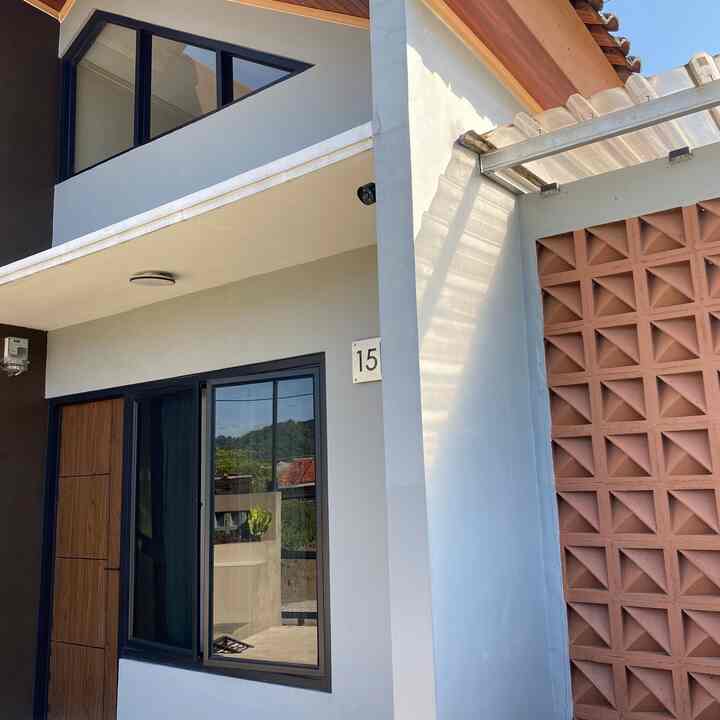 "Sederhana namun tetap Modern"
Konsep yang kami inginkan ketika merencanakan pembangunan rumah ini.

Rumah yang terletak di area persawahan ini mengusung gaya modern tropis dengan dominasi warna mocca dan abu-abu yang memberikan kesan tenang dan modern, namun tetap membaur dengan lingkungan tropis. Dengan bentuk atap pelana asimetris dan jendela segitiga hitam minimalis di bagian atas, menciptakan dinamika visual sekaligus memungkinkan pencahayaan alami memasuki area dalam rumah.

Aksen roster di sisi kanan berfungsi ganda sebagai ventilasi pasif dan ornamen visual yang bertekstur. Sedangkan di sisi kiri terdapat taman kecil di depan rumah yang dihiasi tanaman hias dan batu koral putih, menambah kesan sejuk dan tertata. Pagar expanded metal berwarna hitam memberi kesan modern dan ringan, menjaga privasi namun tetap memperlihatkan keindahan fasad.

#catrumah #pintumasuk #tanamanhias #jendelarumah #inspirasifasad #stylefasad #fasadrumah