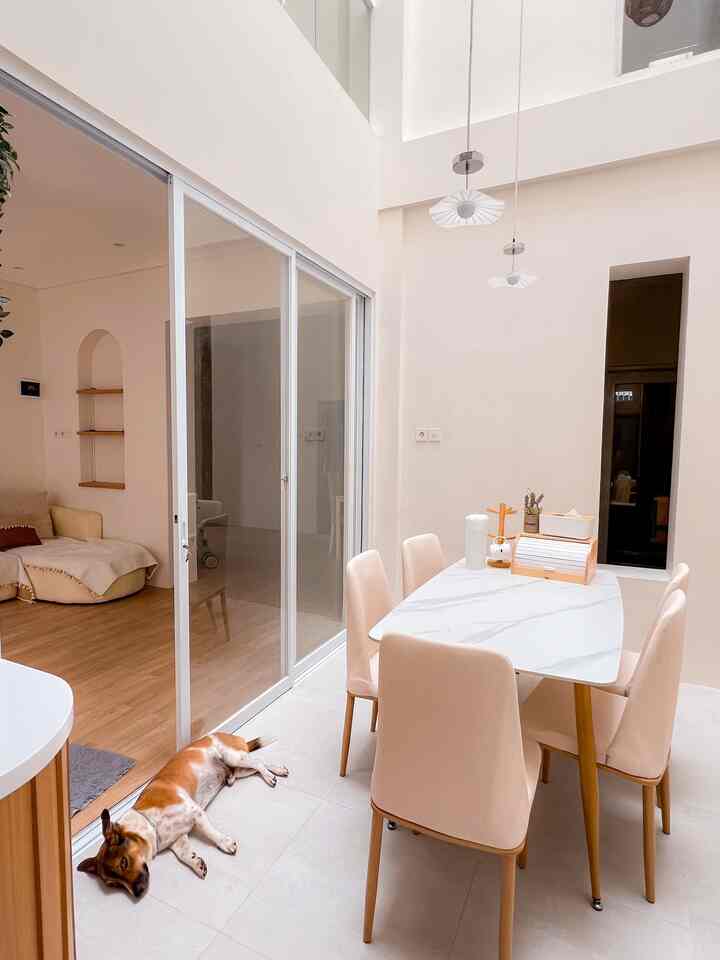 Beige-toned dining room featuring a marble dining table with four chairs and pendant lights creating a cozy atmosphere