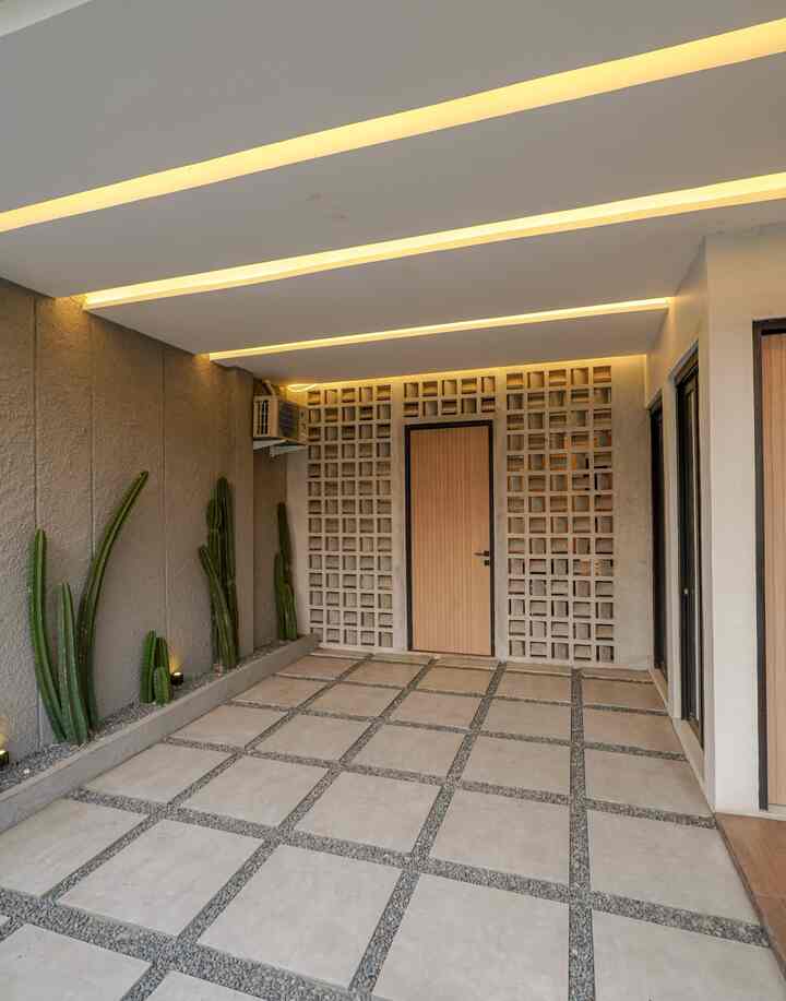 Beige and gray toned entrance area featuring natural cactus plants and indirect modern lighting