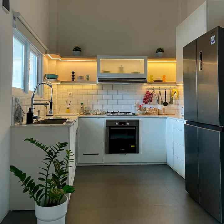 White and silver toned kitchen featuring clean storage and ambient lighting with modern atmosphere
