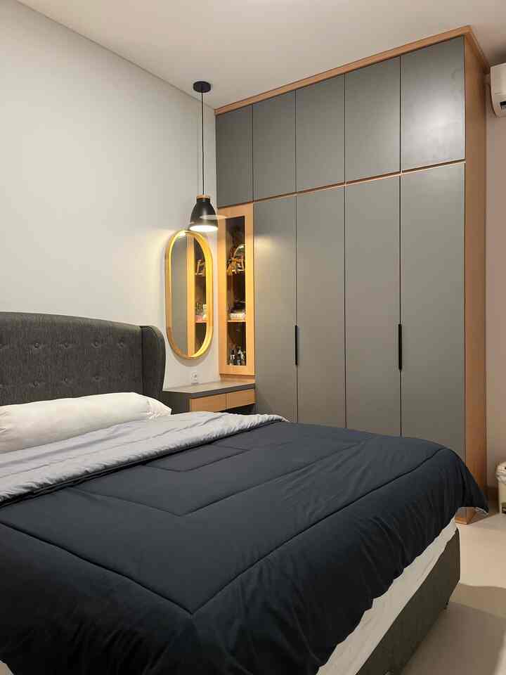 Modern bedroom with gray and navy tones featuring a bed and closet with a clean and minimal ambiance
