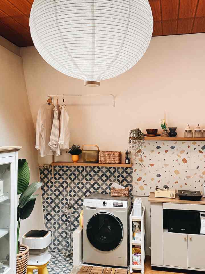 Natural beige-toned long and narrow kitchen featuring a large white pendant light and compact furniture layout with a cozy atmosphere