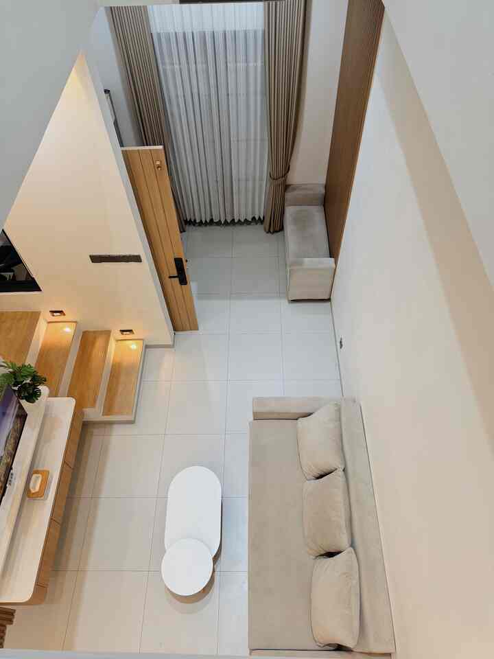 Natural modern living room with beige sofa and bench, white tiled floor, and wooden door creating a clean harmonious interior