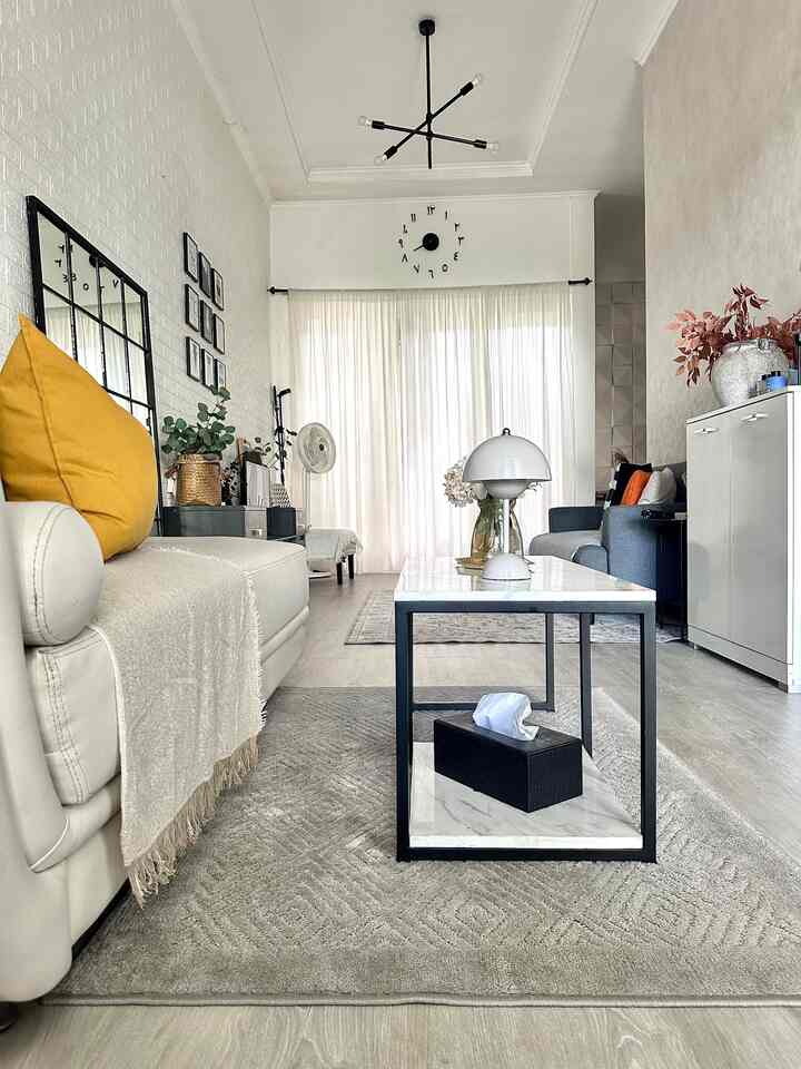 White and blue toned living room featuring coffee table and curtains with a simple, spacious interior atmosphere