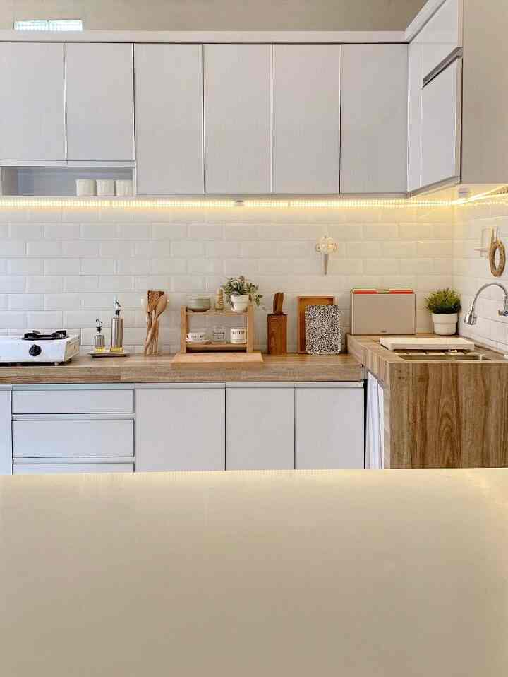 A clean kitchen featuring white and wood tone elements, with sleek and functional storage solutions