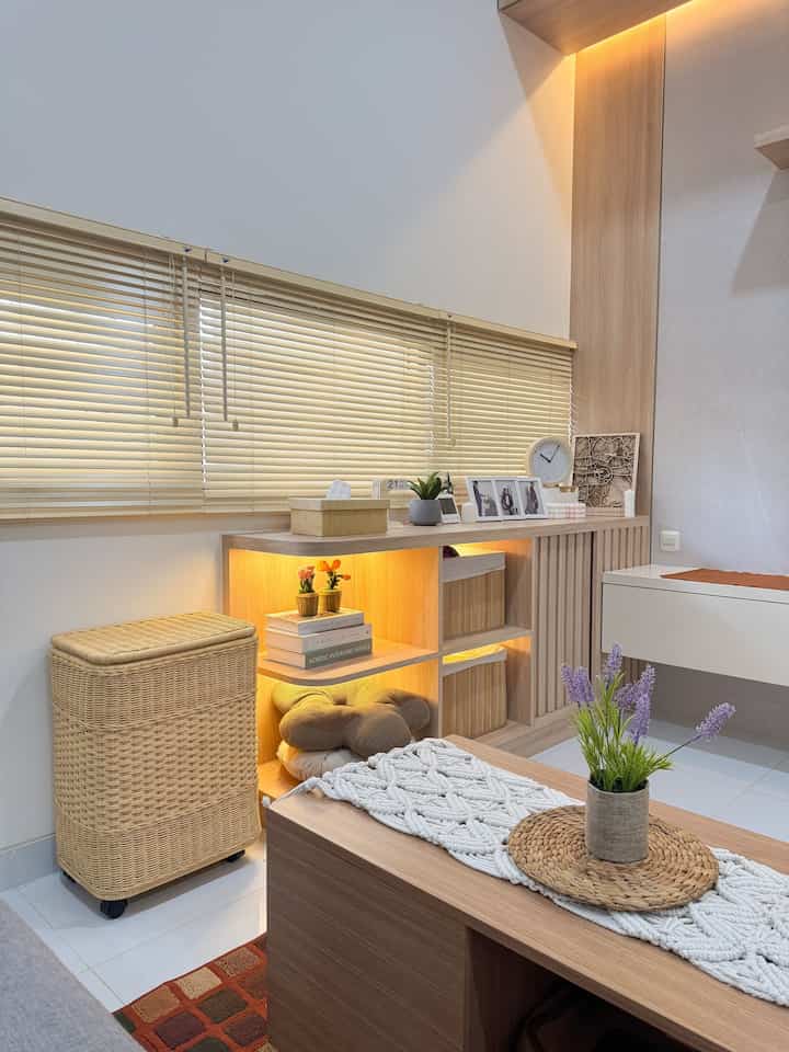Natural-toned living room featuring wooden storage furniture, rattan basket, and lavender pot creating a cozy atmosphere