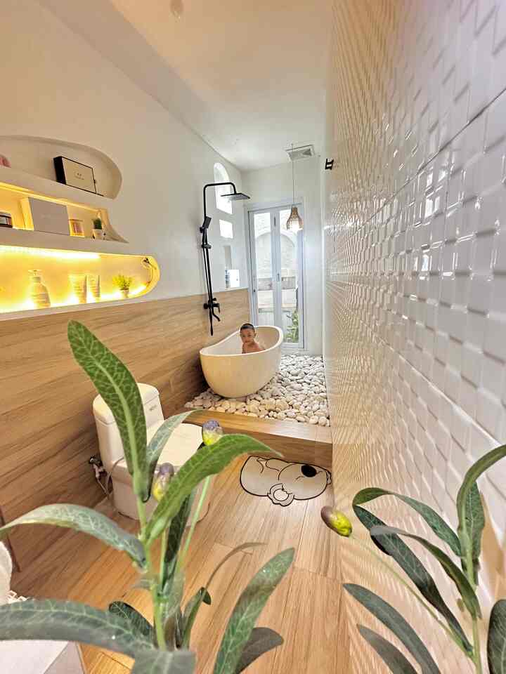 Sebelumnya kamar mandi ini tidak memiliki pintu alumunium dan kaca pada bagian depan. Hanya ada akses pintu kayu yang menyatu dengan kamar.

Karena aku suka suasana terbuka dan full simat, akhirnya jebol tembok bagian depan yang menyatu dengan taman depan. Pasang pintu kaca dan alumunium. 

Boom ternyata hasilnya super cantik banget sukaaa sekali 😍😍 

Bagian lantai aku gunakan granite warna kekayuan, tembok sebelah kiri granite yang sama dengan lantai dna hanya pasang setengah saja, Namun tembok sebelah kanan menggunakan keramik glossy warna putih full sampai atas. 

Untuk cat aku pilih warna putih , waterproof dan efek daun talas, kasih sentuhan arch pada bagian tembok sebelah kiri. 

Dan agar kesan lebih natural pada bagian bawah bathub aku menggunakan batu koral putih yang ukurannya paling besar. 

Gimana menurut kalian ? 

.
.
.

#KeramikKamarMandi  #PintuKamarMandi
#CatKamarMandi  #WarnaKamarMandi 
#DindingKamarMandi  #KeramikDinding 
#KeramikLantai #whitehouse #whitenwood 
#RenovasiKamarmandi
#BathroomMakeOver
#InspirasiKamarMandi