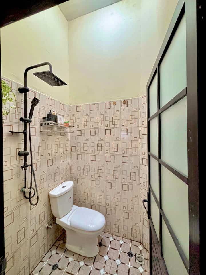 Kamar Mandi Bawaan Developer —

Kalau ada satu sudut rumah yang jadi saksi bisu sejak awal, kamar mandi ini juaranya. Ini adalah kamar mandi bawaan developer, belum pernah direnovasi sama sekali hanya ganti pintu saja sejak serah terima kunci. Dinding keramik motif kotak-kotak khas tahun 2000-an dan shower hitam kami tambahkan untuk menghemat space 1,5m x 1,5m karena kami tidak menggunakan bak mandi.

Meski tampilannya sudah kalah gaya dibanding tren kamar mandi kekinian, ruangan ini tetap berfungsi dengan baik apalagi ketika lelah dengan hiruk pikuk pekerjaan kami dikantor.

Ada rencana makeover? Tentu. Tapi untuk saat ini, biarlah kamar mandi ini tetap tampil apa adanya—sebuah pengingat akan awal mula perjalanan rumah ini.

#KeramikKamarMandi #PintuKamarMandi #CatKamarMandi #WarnaKamarMandi #DindingKamarMandi #KeramikDinding #KeramikLantai #ShowerHitam #RakSabun #RenovasiKamarMandi #BathroomMakeOver #InspirasiKamarMandi