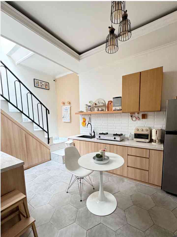 White and wood tone small kitchen space featuring a simple dining table and chair with a cozy atmosphere for a single household