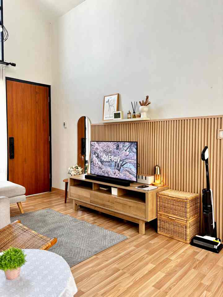 Minimal living room in wood tones and white, featuring a sofa and TV stand in a cozy setting