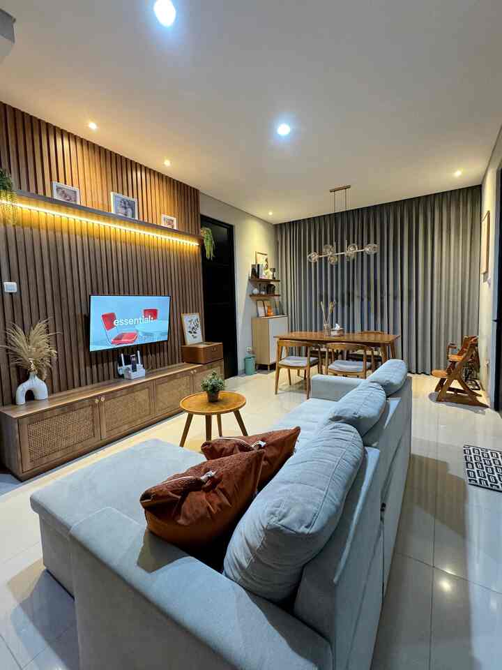 Light gray sofa and wood-tone dining table arranged in a modern open living and dining room