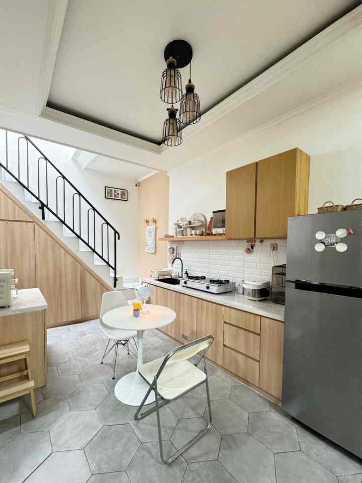 White and wood toned open kitchen and dining room featuring simple modern furniture and pendant lighting with cozy atmosphere