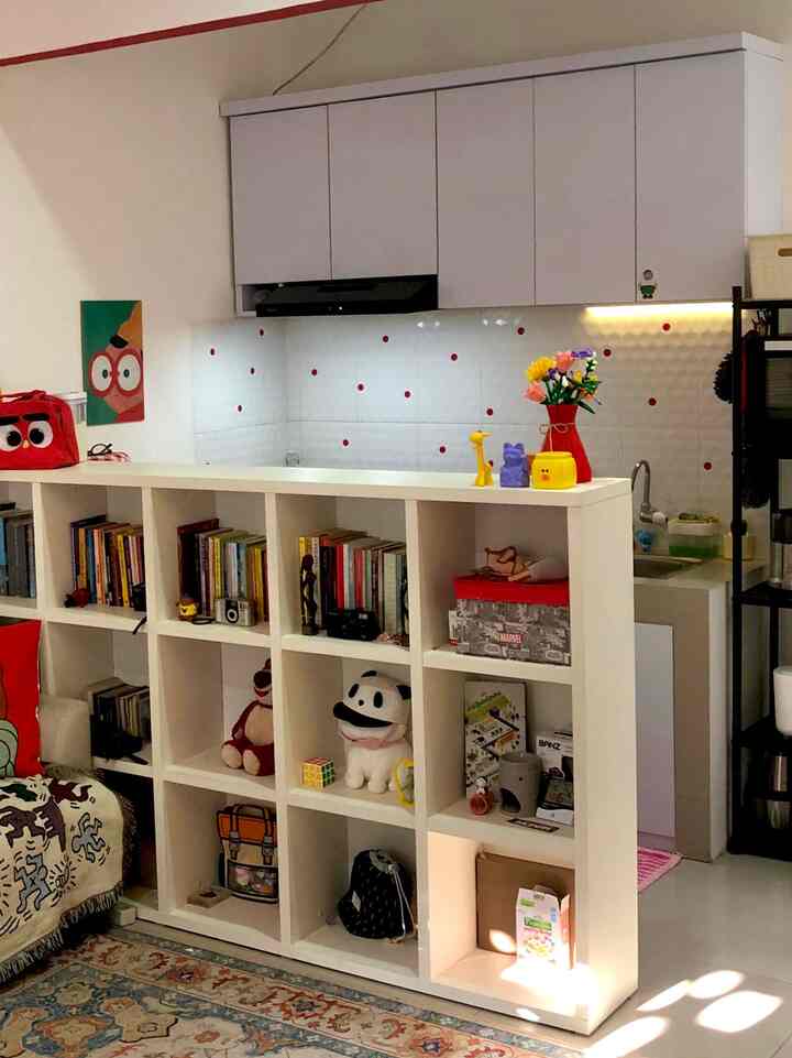 White-toned kitchen and bookshelf in a cozy space, featuring various accessories and books arranged for practical interior design
