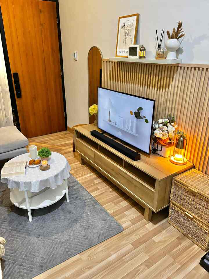 Light brown toned living room featuring gray sofa and white coffee table with a cozy atmosphere