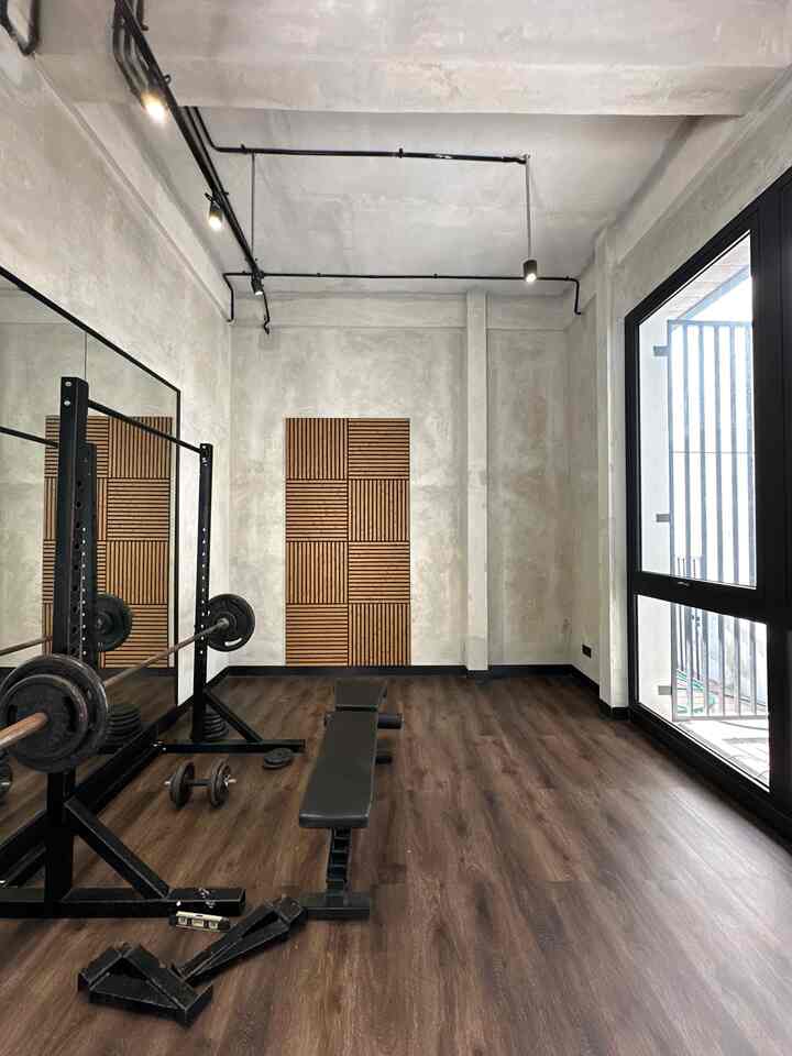 Home Gym Rumah Bolu,
A room with a different concept, with unfinished walls, industrial without a ceiling, and wooden accents that make this room unique. To add light, Bolu added window glass & used a full body mirror to support exercise activities & make the room look more spacious.

#UnfinishedWalls #IndustrialLook #LantaiKayu #LantaiParket #FullBodyMirror #Panelku #HomeGym