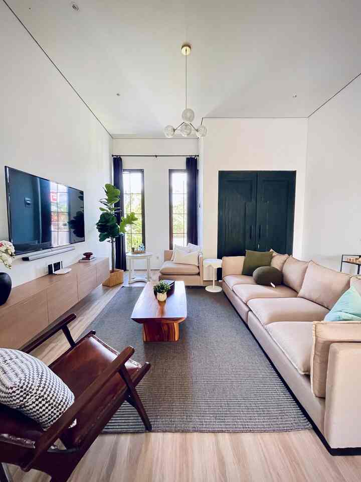 Bright white living room with natural-tone sofa and wooden coffee table, creating a cozy atmosphere