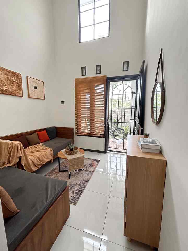 Hai selamat datang di rumah harvi, yuk masuk dulu duduk sini ☺️

Setiap sudut rumah layak untuk tampil cantik loo! Termasuk ruang tamu rumah harvi. Ruang tamu kami ukurannya sangat mini 3x3 meter tapi memiliki ceiling yang tinggi -+ 5 meter, terdapat kaca besar pada bagian atas supaya cahaya matahari dengan bebasnya bisa masuk dan bisa menghemat listrik karena pencahayaan cukup!

Kami memilih furniture dengan warna-warna kayu dan earth tone supaya ruangan lebih terasa cozy dan nyaman dipandangan.  Karena ceiling yang tinggi, kami memutuskan untuk custom sofa berkaki supaya lantai lebih terlihat dan ruangan jadi terasa lebih lapang. Kami juga custom bench storage untuk menambah tempat penyimpanan.

💡Tips untuk ruangan dengan ceiling tinggi 
1. Gunakan sofa berkaki / sofa yang tinggi supaya lebih seimbang
2. Tambahkan elemen tanaman indoor dengan model tinggi keatas
3. Gunakan floor lamp tinggi atau lampu gantung yang panjang

#sofaminimalis #cerminbulat #throwblanket #keranjanganyaman #sofaberkaki #standinglamp #ilalangartificial #karpetaesthetic #benchstorage #rollerblind #stylingruangtamu #dekorasilivingroom #inspirasilivingroom