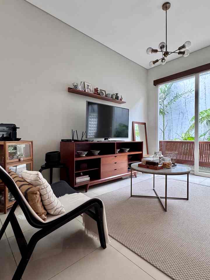 Area Living Room adalah area yang tempat kumpul kami, untuk nonton bareng, main catur, nyemil dan kopi sore. 

Penataan ruang menjadi sesuatu yang penting, agar nyaman kami memilih sofa besar yang empuk agar betah berlama lama duduk. Storage cemilan di sisi kiri TV dan mesin kopi agar mudah dijangkau, dan meja tengah untuk meletakan toples, gelas dan papan permainan.

Ada cermin di dinding agar rumah terlihat lapang, pemanfaatan furniture lama dan pajangan memorable membuat rumah lebih homey tidak kaku dan warna warna earth tone membuat suasana lebih nyaman dimata.

Dan jendela besar dengan bukaan lebar disisi kanan serta kami menanam banyak tanaman diarea luar agar teduh cahaya masuk tidak menyilaukan dan sirkulasi udara juga bagus..

#sofabesar #catrumahminimalis #furniturelama #furniturekayu #topleskaca #karpetwarnanetral #lampugantung #kacabesar #bantalsofa #stylingruangtamu #dekorasilivingroom #inspirasilivingroom