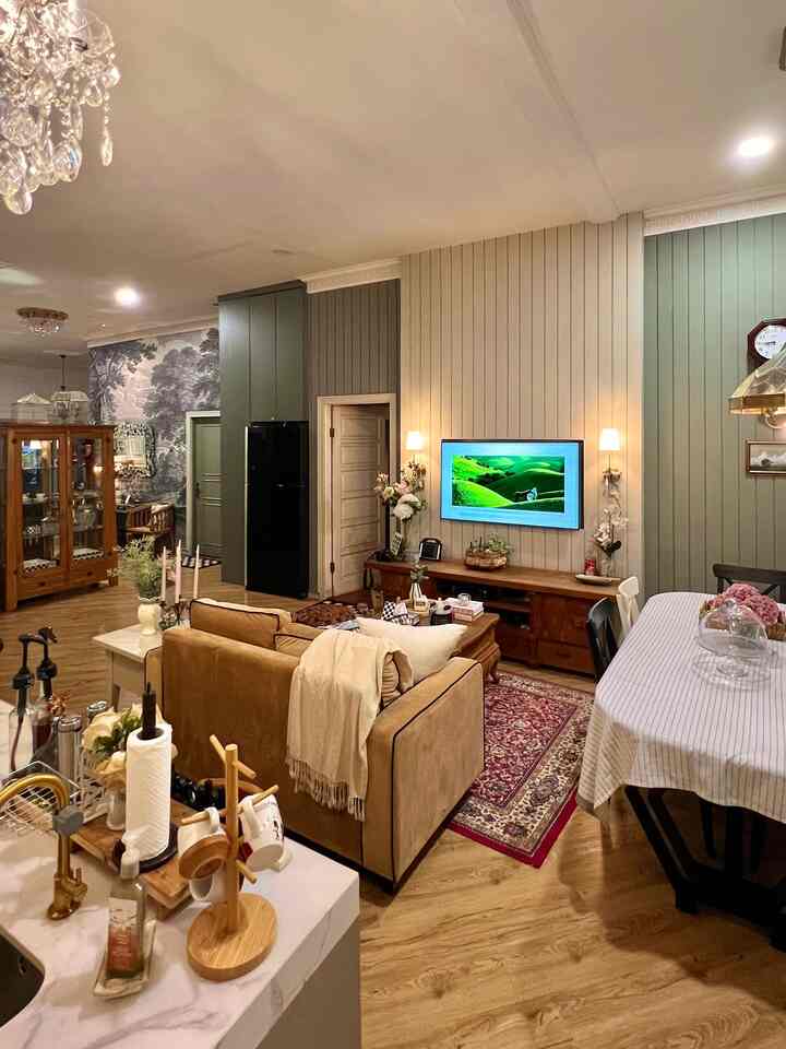 Natural wood tones and beige sofa furnished living room with kitchen and dining area creating cozy atmosphere