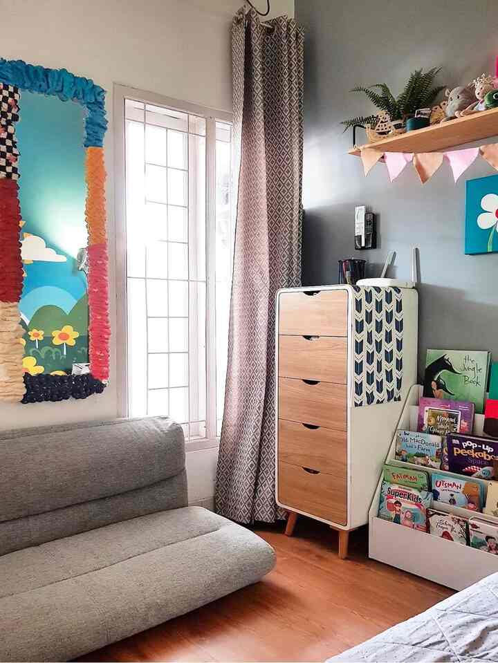 Blue and brown toned kids' room featuring a bookshelf with children's books and a simple modern sofa, creating a cozy atmosphere