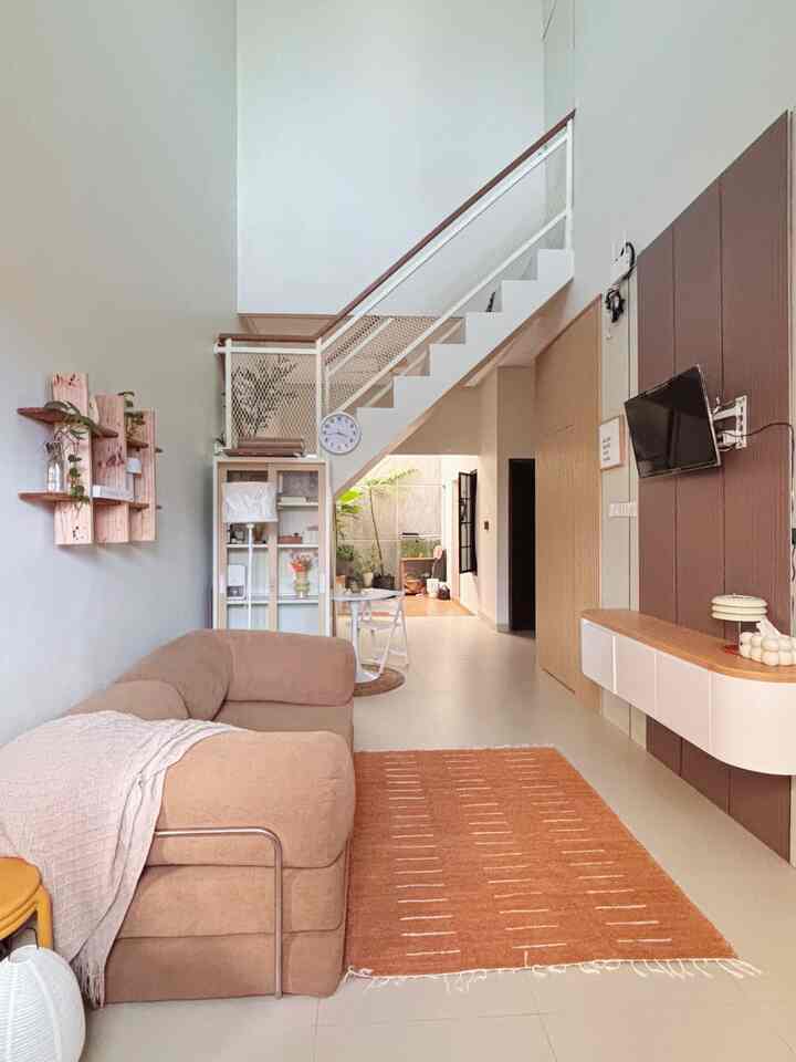 Beige and ivory wide living room featuring a simple natural sofa and an orange carpet creating a cozy atmosphere