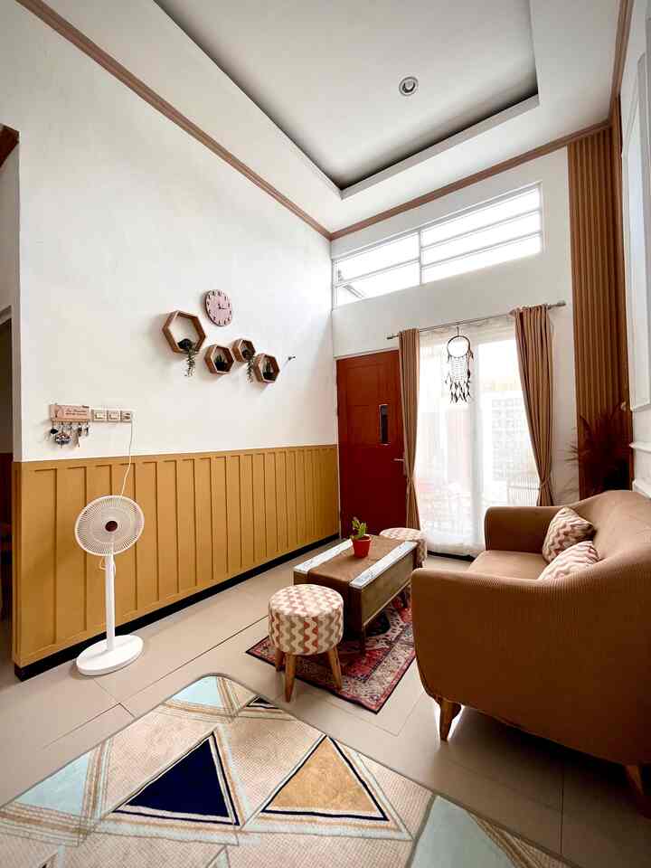 White and wood-tone living room featuring brown sofa, coffee table, hexagonal wall decor creating a cozy atmosphere