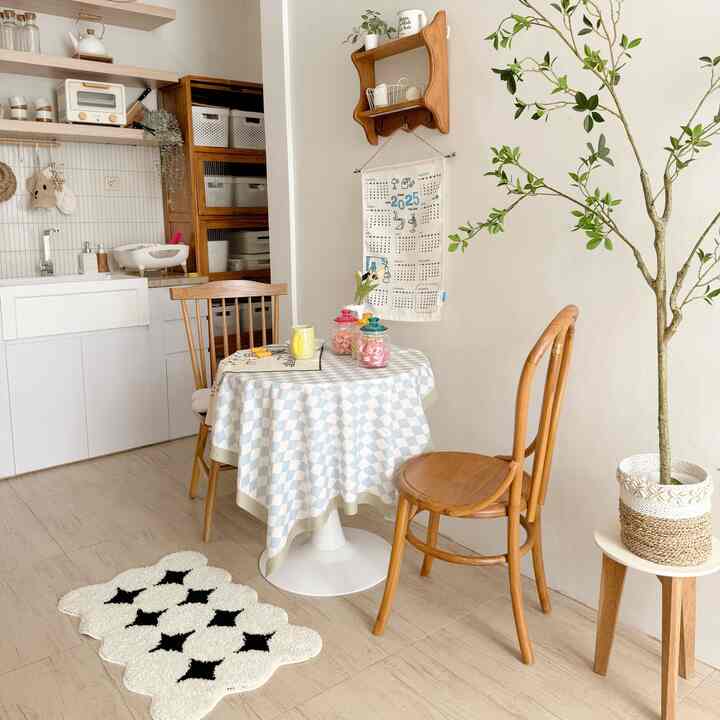 White and wood tone dining room featuring a round table and wooden chairs creating a cozy cafe style atmosphere.