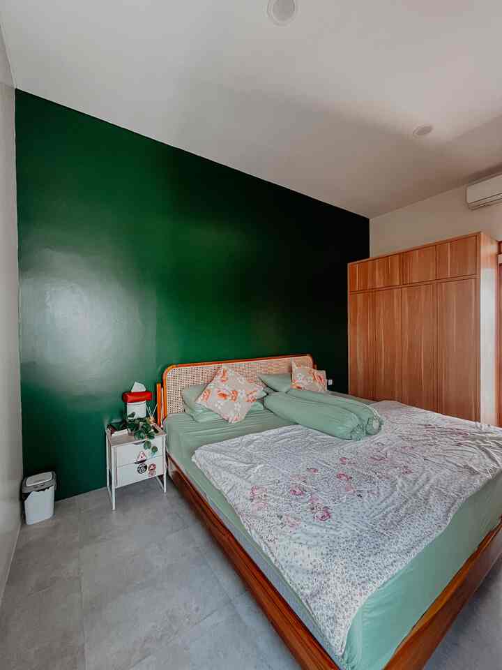 Master Bedroom: Fungsional Dulu, Dekor Nanti 💚

Caption:
Kamar tidur utama di rumah ini sengaja dibuat simpel dan fungsional dulu. Warna cat dominan gading bikin ruangan terasa terang dan hangat, sementara satu sisi dinding dicat hijau pekat sebagai focal point — biar tetap ada sentuhan karakter tanpa perlu banyak dekorasi.

Dipan rotan dan lemari minimalis dengan finishing HPL motif kayu jadi pilihan utama karena fungsional dan tetap estetik. Belum ada banyak hiasan, karena prioritas saat ini: memenuhi kebutuhan dasar rumah dulu.

Kadang rumah nggak harus langsung “jadi”, cukup dirancang dengan bijak sesuai kebutuhan dan kemampuan 🫶

#masterbedroom #kamartidurminimalis #rumahminimalis #homelivingindonesia #kamartidurtropis #bedroomideas #focalpointwall #interiorrumah #kamartidursederhana #rumahidaman